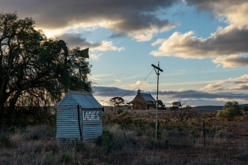 old outside toilet with church in background - Australian Stock Image