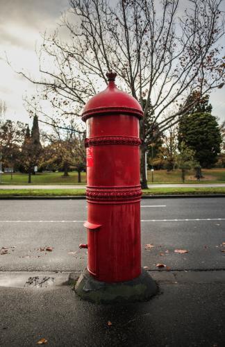 Old style red post box on the street in Melbourne