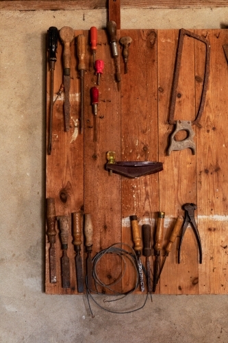 old tools hanging on wooden board - Australian Stock Image