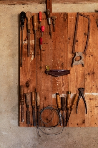 old tools hanging on wooden board
