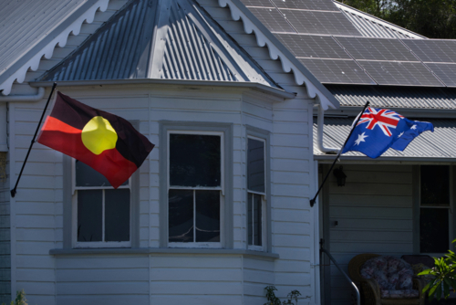 Old weatherboard home Aboriginal and Australian flags - Australian Stock Image