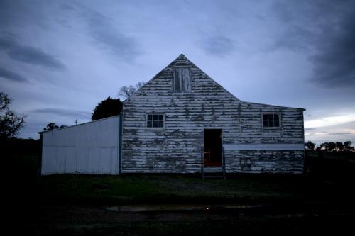 Old white wooden farm shed at dusk - Australian Stock Image