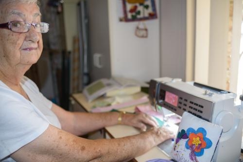 Old woman using modern sewing machine