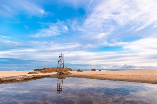 Old wooden lifeguard, shark lookout tower on Redhead Beach with reflection - Australian Stock Image