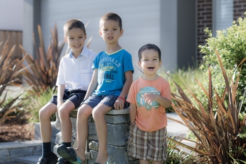 Older brother says goodbye to his siblings on his first day back at school - Australian Stock Image