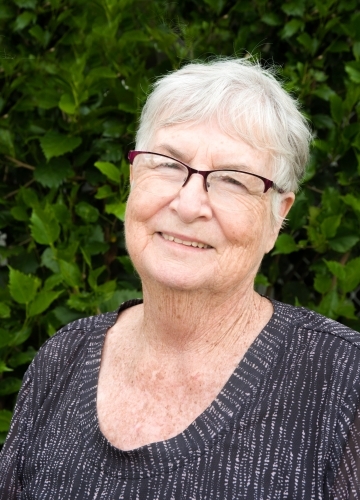 Older lady standing outdoors smiling. - Australian Stock Image