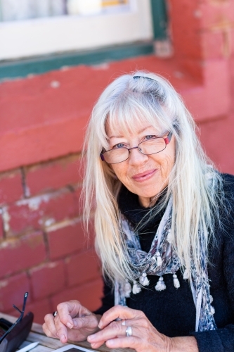 older lady with a scarf looking over rim of glasses - Australian Stock Image