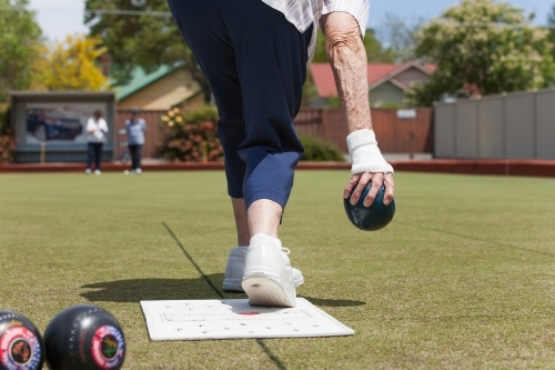 Older woman delivering a lawn bowl - Australian Stock Image