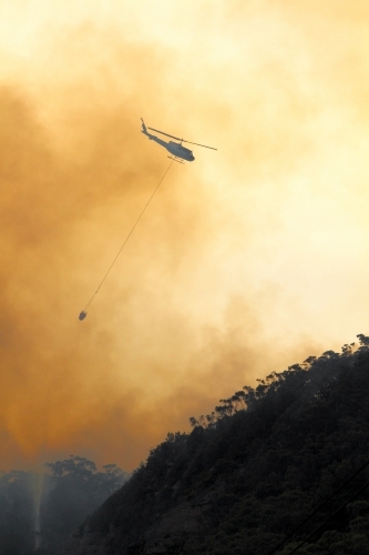 One fire fighting helicopter dumping water onto a bushfire on Maddens Plains, Illawarra, NSW