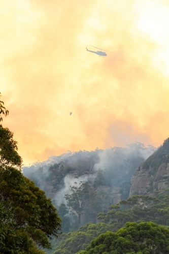 One fire fighting helicopter dumping water onto a bushfire on Maddens Plains, Illawarra, NSW