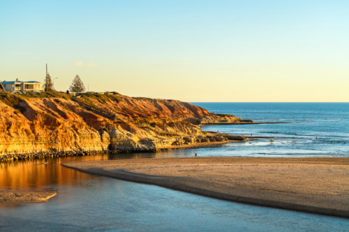 Onkaparinga River mouth with people walking around at sunset, South Port Beach, South Australia - Australian Stock Image