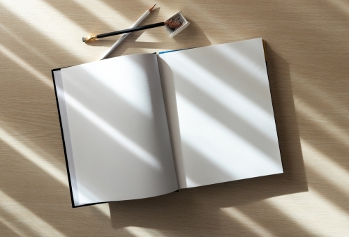 open book with blank pages and pencils - Australian Stock Image