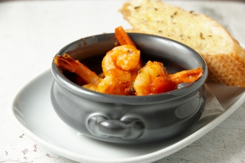 Orange buttered shrimp in a pot - Australian Stock Image