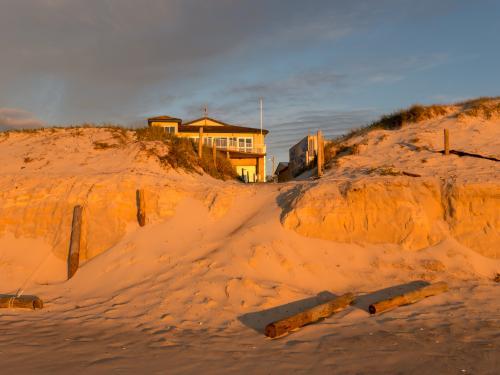 Orange sunlight on beach erosion caused by a big storm - Australian Stock Image