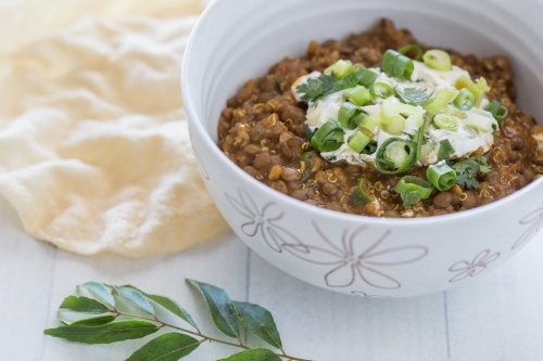 Organic Bowl of vegetarian Lentil Dahl with a papa-dum and lime leaves - Australian Stock Image