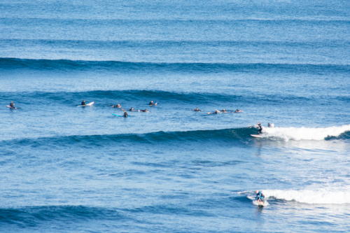out of focus non focus surfers riding waves and waiting for a wave - Australian Stock Image