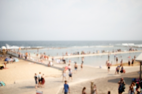 Out-of-focus photo of crowded beach in Newcastle NSW on a summer's day