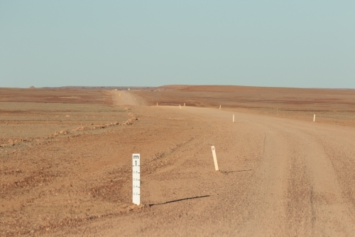 Outback dirt road with flood water gage - Australian Stock Image