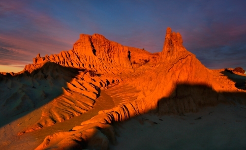 Outback landforms sculpted over time by nature catch the last light of a setting sun