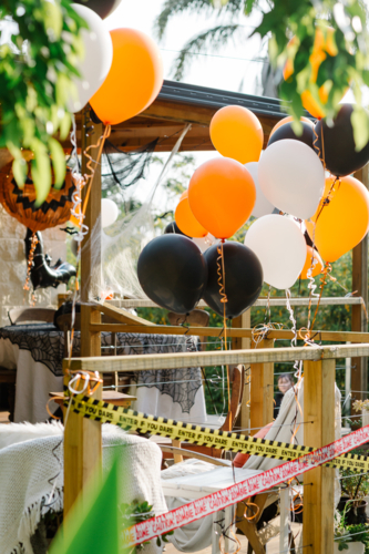 Outdoor patio decorated for a Halloween celebration with orange, black, and white balloons - Australian Stock Image