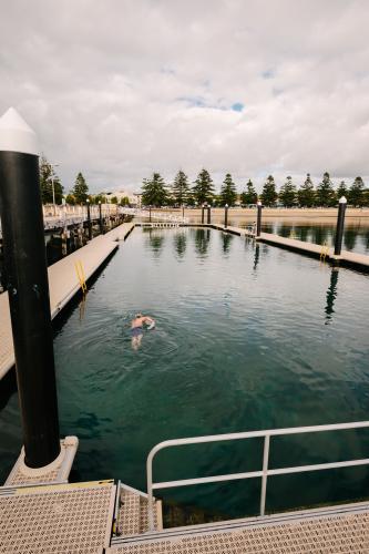 ocean swimming pool with one anonymous swimmer - Australian Stock Image