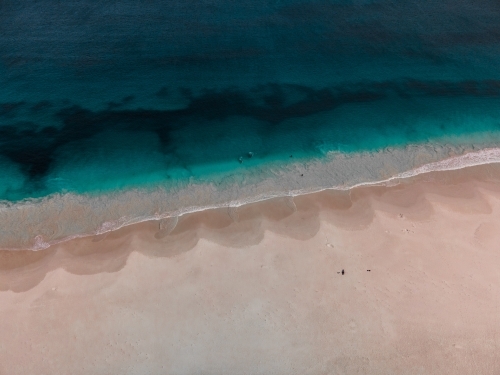 Overhead aerial shot of ocean waves on sandy beach - Australian Stock Image