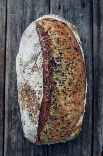 Overhead shot of organic soybean and linseed sourdough on wooden bench - Australian Stock Image