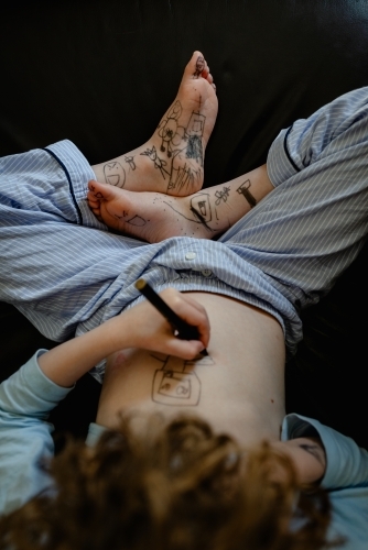 Overhead view of a young boy drawing on his body