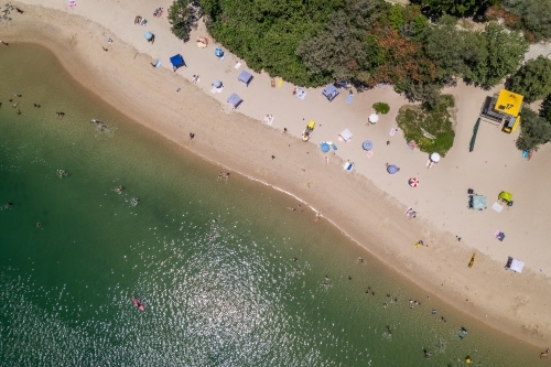 Overhead view of busy beach day for sunbathers and beach patrol - Australian Stock Image