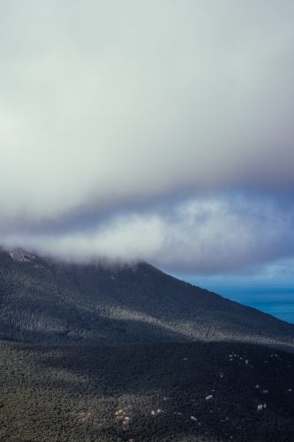 Overlooking rock formations and open sea in Victoria shrouded with clouds - Australian Stock Image