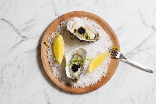 Oysters, topped with caviar on a plate