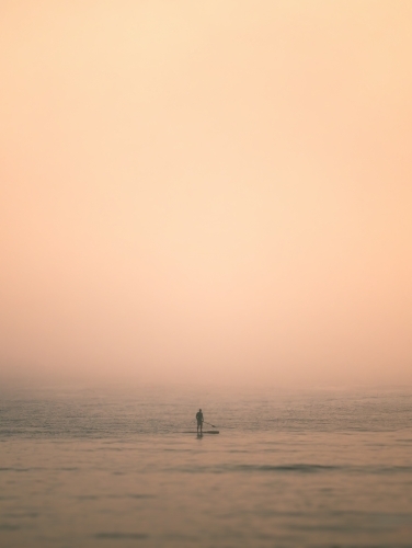 Paddleboarder in Heavy Fog on the Ocean - Australian Stock Image
