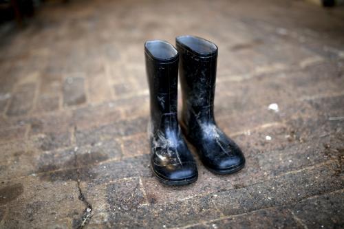 Pair of black gumboots on paved ground - Australian Stock Image