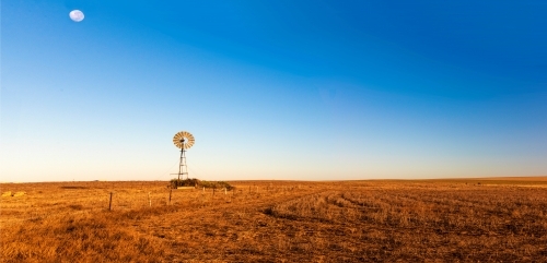 Panoramic view of early morning landscape with a windmill. - Australian Stock Image