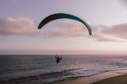Paraglider soaring gracefully above the ocean at twilight - Australian Stock Image