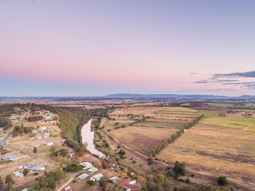 Pastel dusk sky over view of distant farm paddocks and cliff - Australian Stock Image