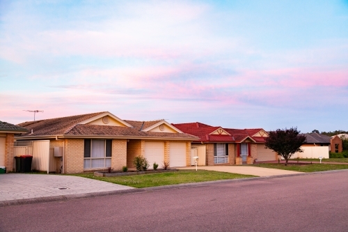Pastel sky at sunset looking along street with brick houses in singleton - Australian Stock Image
