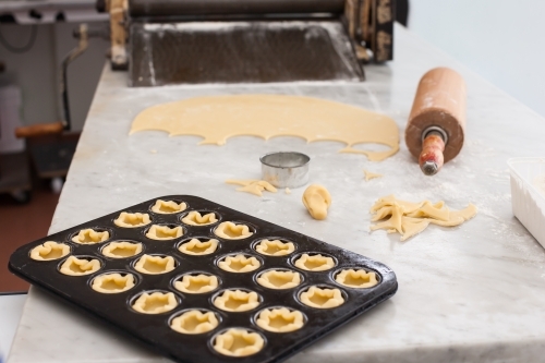 Pastry in a baking tray with rolling pin & dough - Australian Stock Image