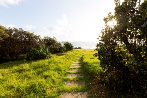 Pavers across a grassy headland leading to the ocean - Australian Stock Image