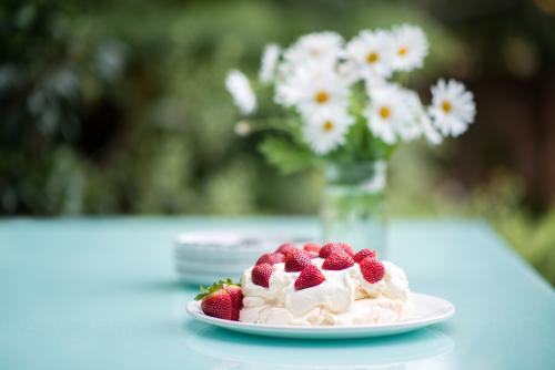 Pavlova with strawberries on an outdoor table in summer