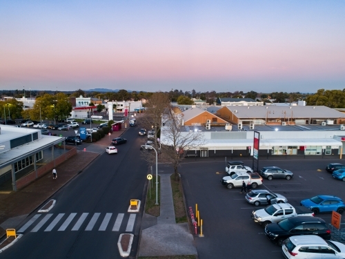 Pedestrian crossing between carpark and shopping centre in town at dusk seen from aerial view - Australian Stock Image