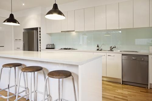 Pendant lighting and bar stools in modern townhouse - Australian Stock Image