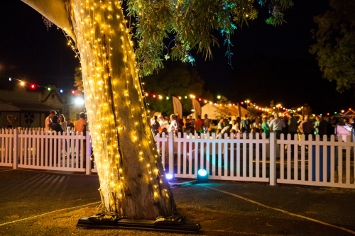 Fairy lights and people at a party at night - Australian Stock Image