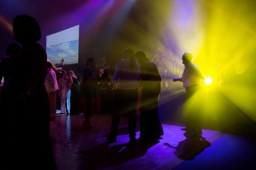 People dancing on a dance floor with bright lights - Australian Stock Image