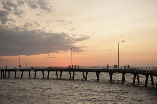 People fishing from Derby jetty at sunset - Australian Stock Image