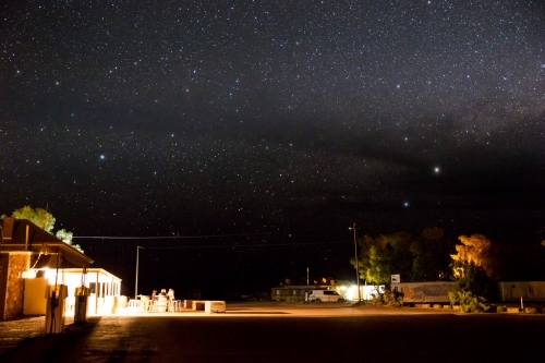 People outside hotel at night under a starry sky - Australian Stock Image