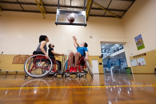 people playing wheelchair basketball on an indoor court