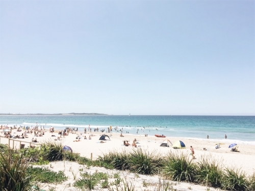 People relaxing on the beach in summer - Australian Stock Image