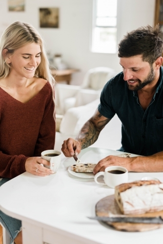 People sitting at a table drinking coffee and eating artisan bread - Australian Stock Image