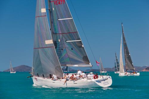 People sitting on a racing yacht at Hamilton Island Race Week - Australian Stock Image